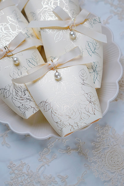 Boites dragées mariage chic, contenants à dragées avec ruban et perle. Boite cadeau invités, couleur blanc avec impression de fleurs argenté et ruban crème avec perle. 
